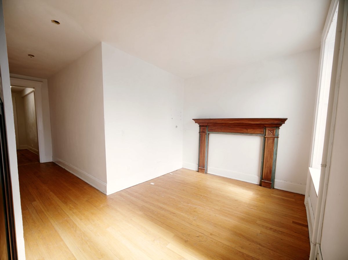 An empty living room with an original painted mantelpiece